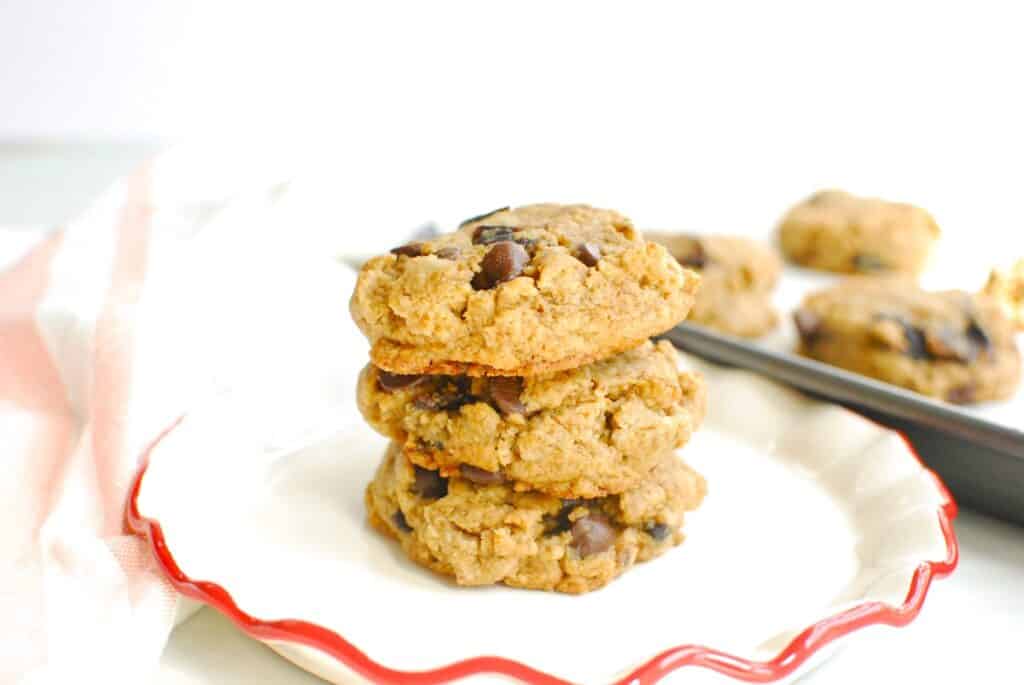 A stack of three tahini prune chocolate chip cookies on a plate.