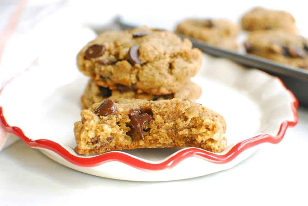 A close up of a tahini cookie that's been bitten into and has gooey chocolate in the center.