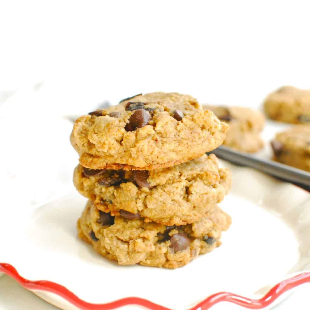 Three chocolate chip tahini cookies stacked on a small plate.