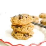 Three chocolate chip tahini cookies stacked on a small plate.
