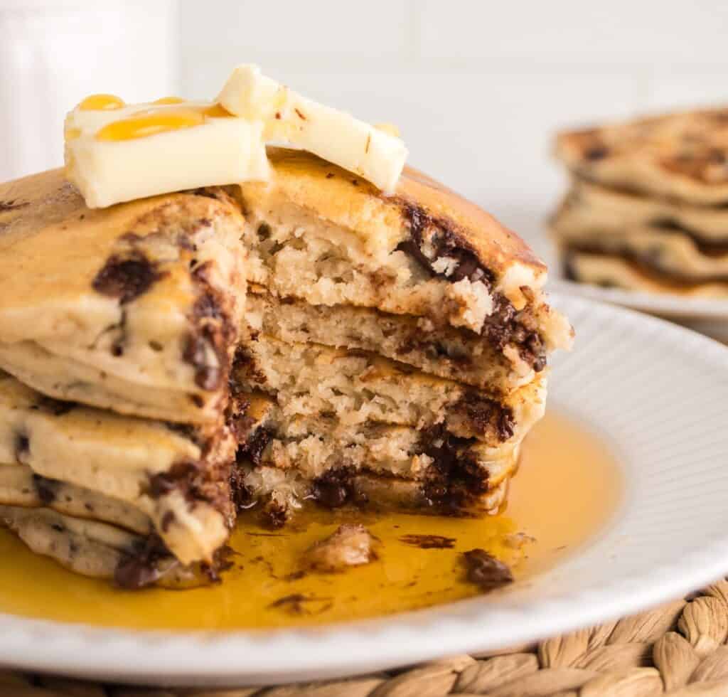 A stack of pancake with a bite cut out of it.