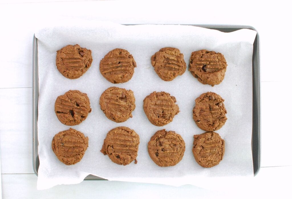 A parchment-lined baking sheet with just-baked cookies.