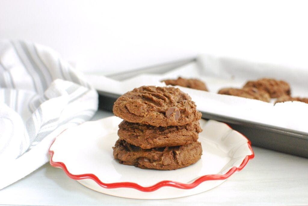Three dairy free double chocolate peanut butter cookies stacked on top of each other.
