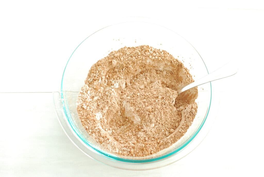 Flour, cocoa powder, baking soda, and salt mixed together in a glass bowl.
