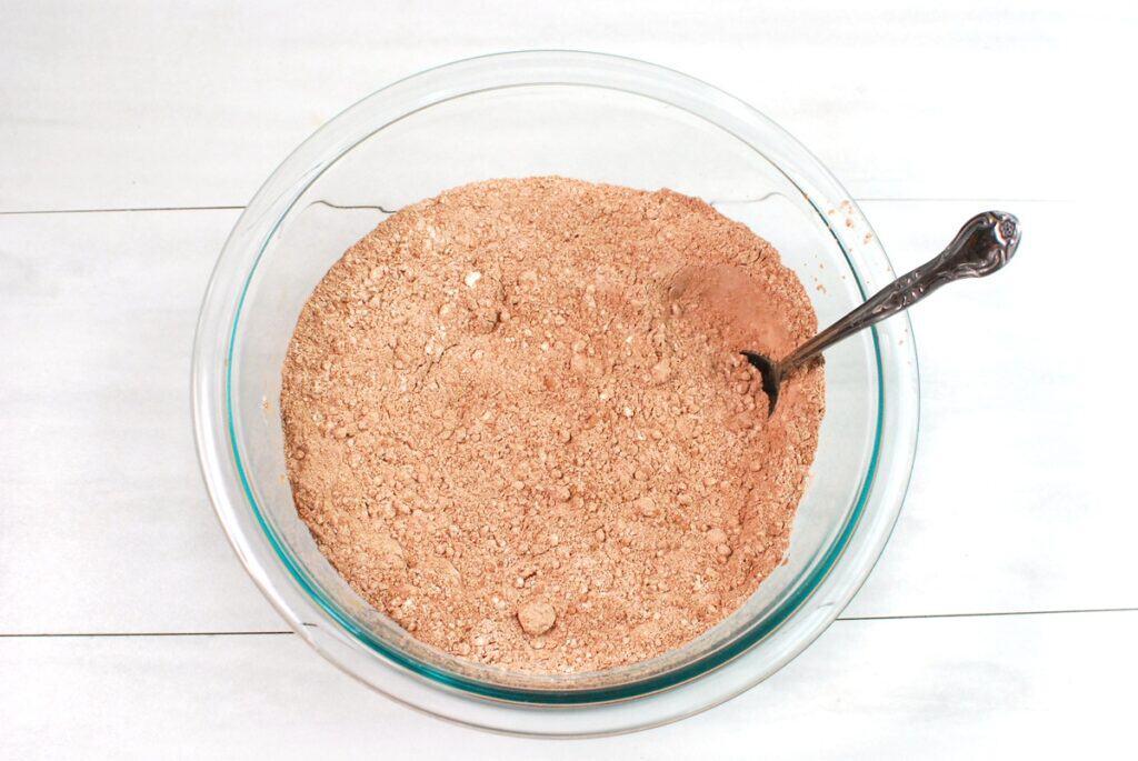 Flour, cocoa powder, baking soda, and salt mixed together in a glass bowl.