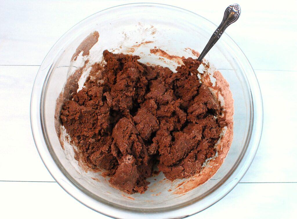 Chocolate cookie dough in a glass bowl.