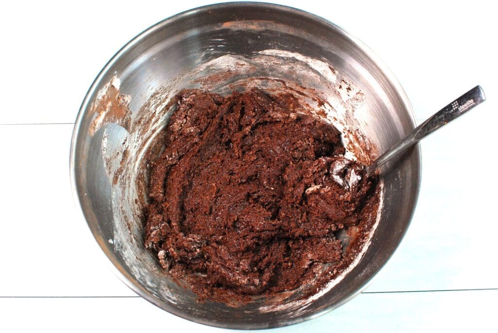 Cookie dough in a silver bowl.
