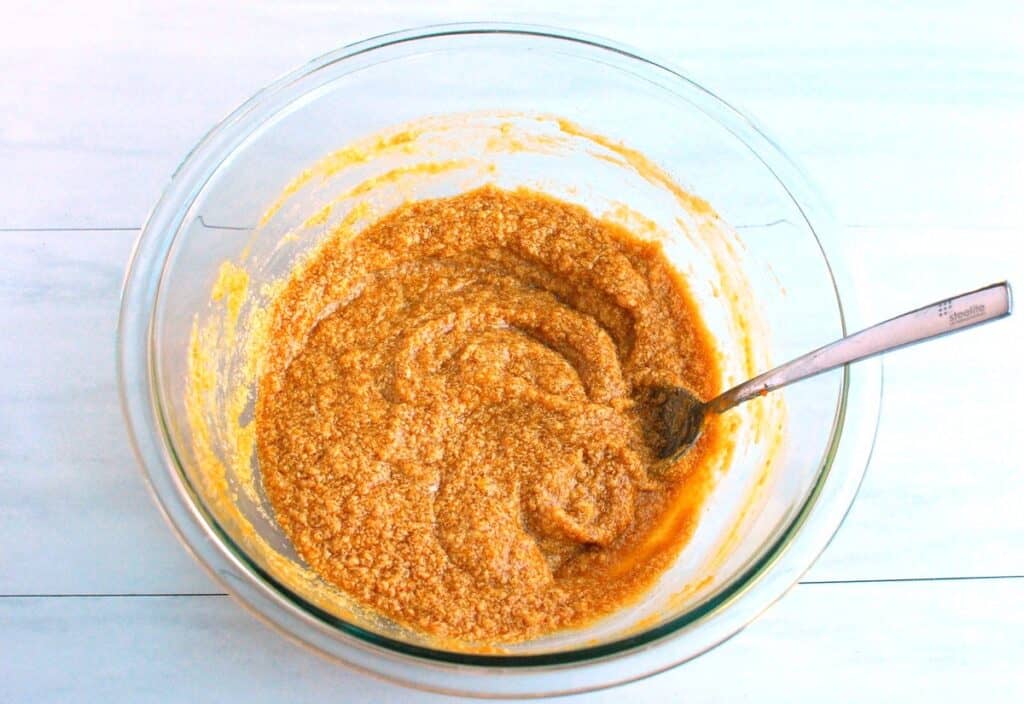 Dairy-free butter, egg yolk, pumpkin puree, sugar, brown sugar, and vanilla mixed together in a bowl.