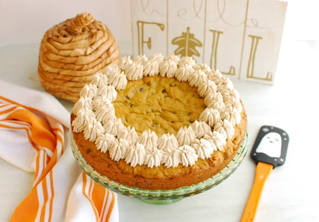 A dairy free pumpkin cookie cake on a cake platter.