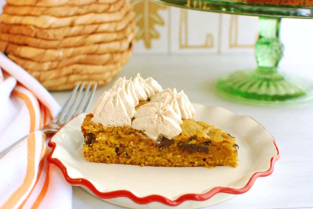 A slice of dairy free pumpkin spice cookie cake topped with frosting.