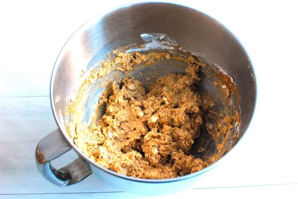 Cookie dough in a silver mixing bowl.