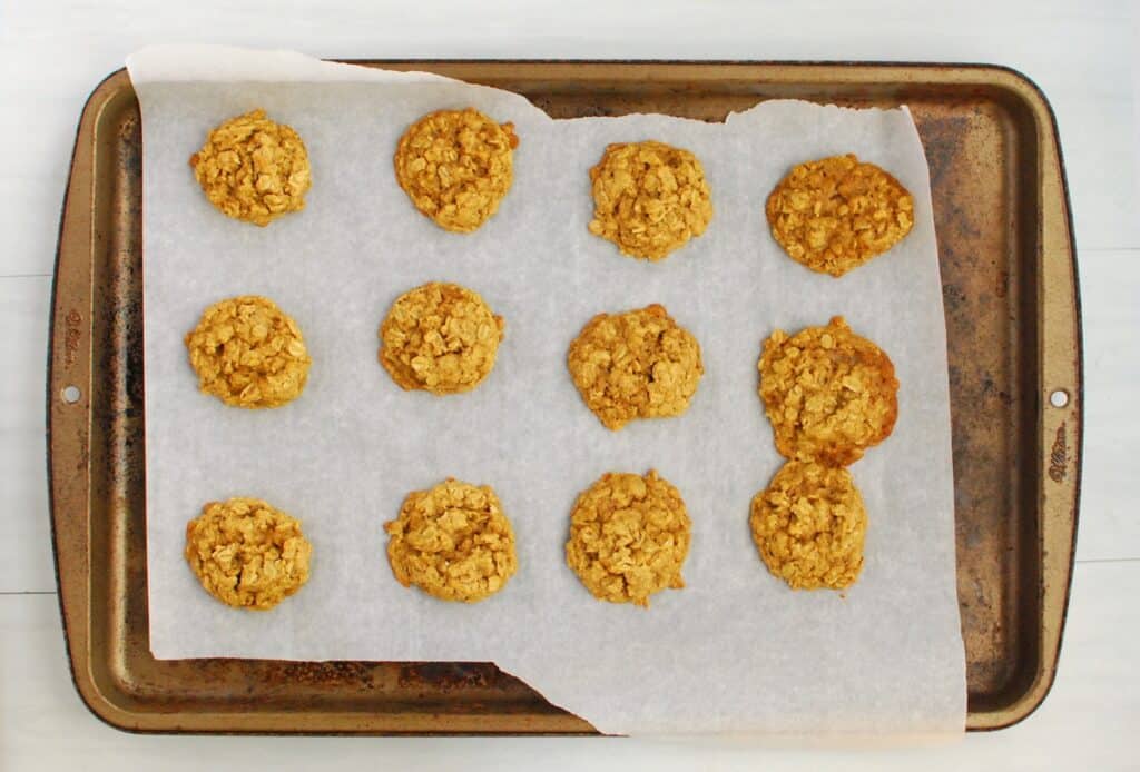A parchment-lined baking sheet with just-baked cookies.