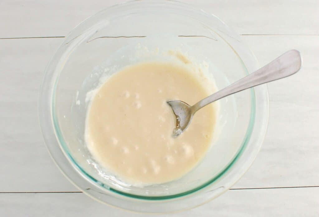 Icing in a small glass mixing bowl.